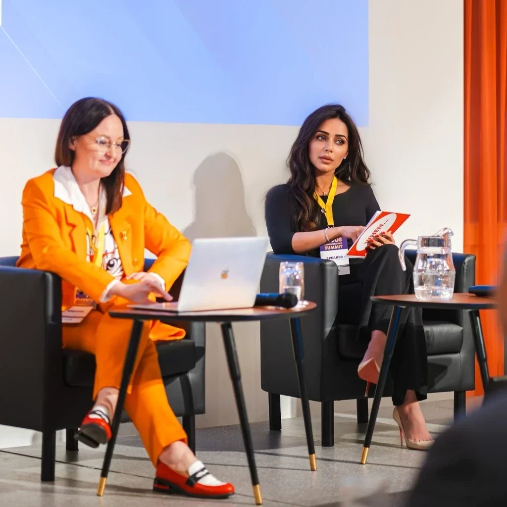 Lima Alhawamdeh discussing digital communications trends with moderator in bright orange suit during Davos World Communications Summit 2025 panel session