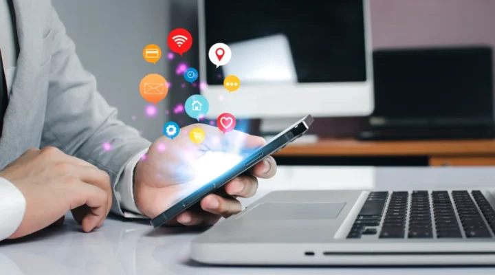 Person using smartphone with digital icons hovering.